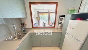A compact kitchen with a sink, a microwave, and a refrigerator. - Seafront apartment with terrace and parking in Platja d'Aro (Platja d'Aro)