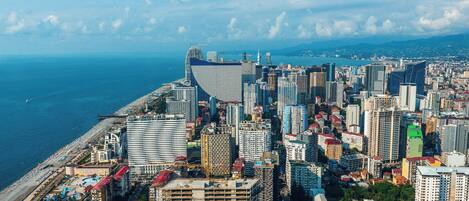 Un paisaje urbano costero con edificios altos, una playa y una vista despejada del mar.