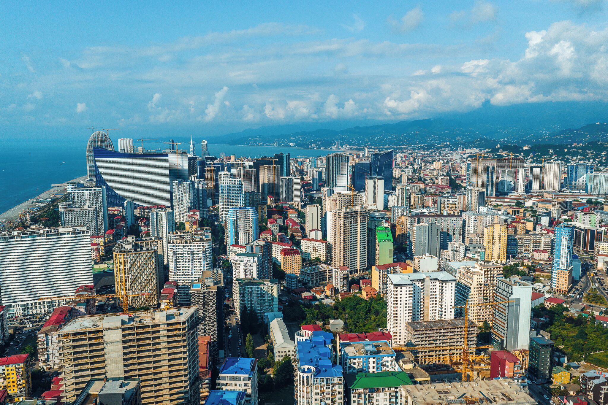 Um horizonte urbano denso, repleto de edifícios altos e variados, alguns em construção.