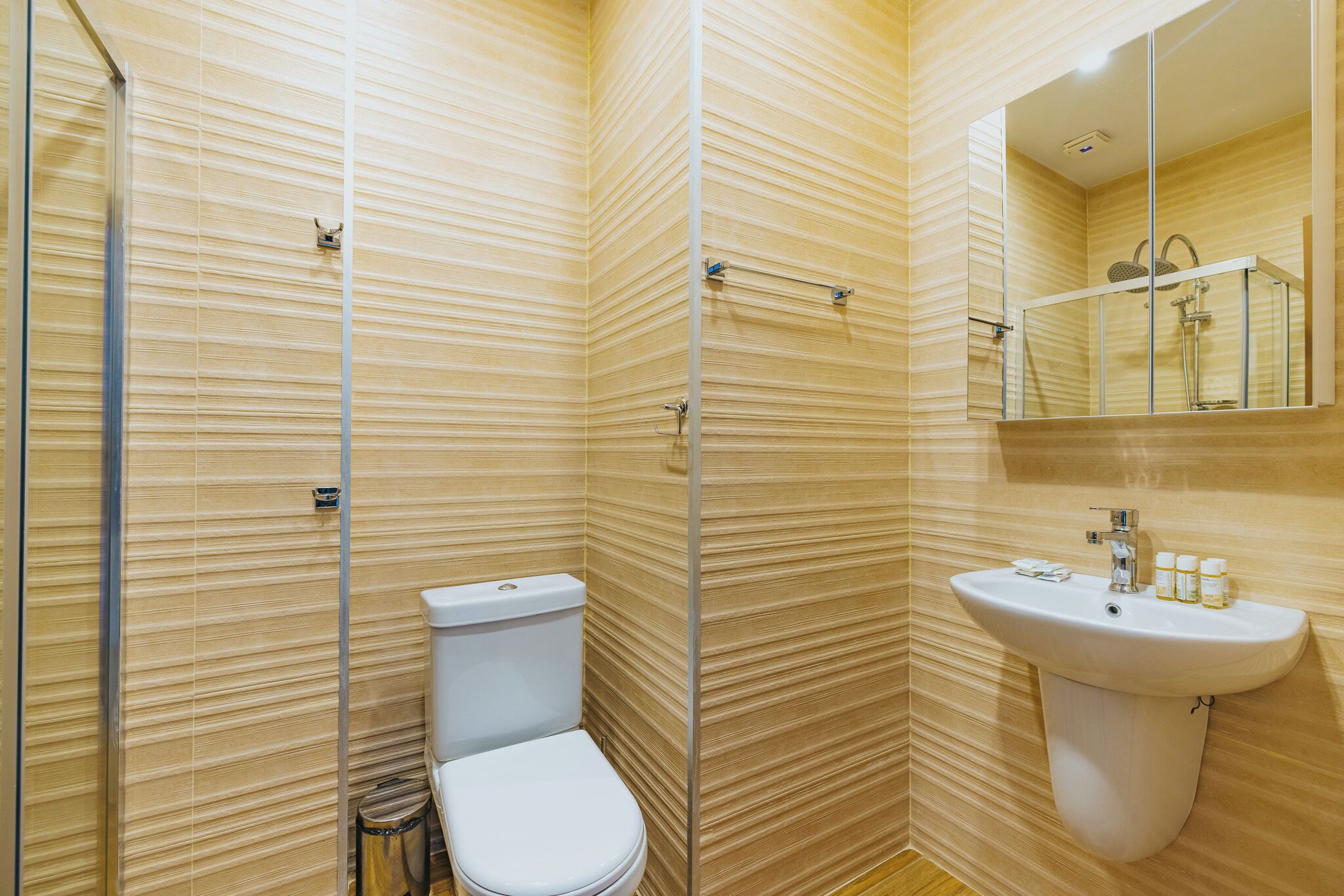 Une salle de bain comprenant des toilettes, un lavabo et un espace douche.