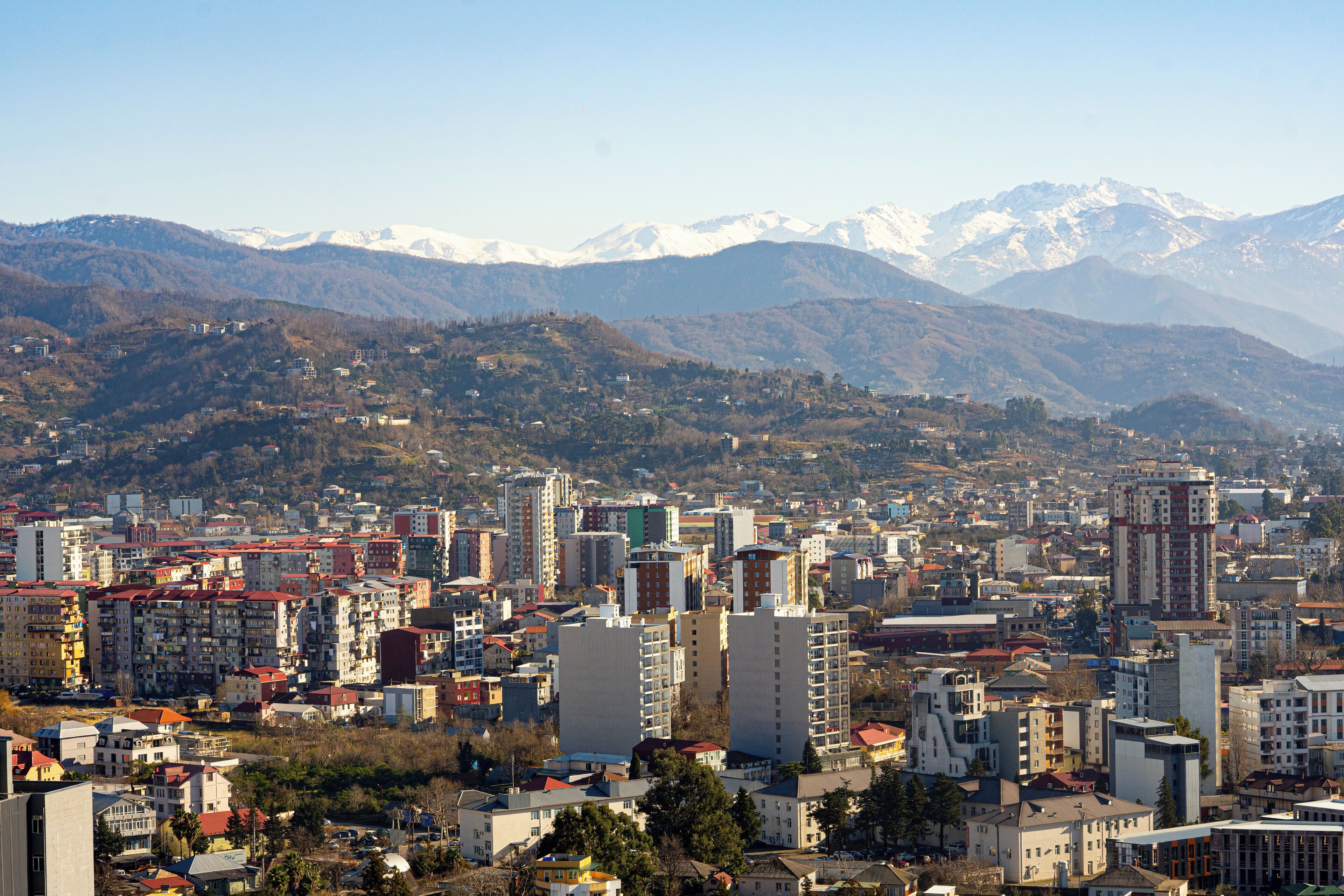 A cityscape with a view of snow-capped mountains in the background.