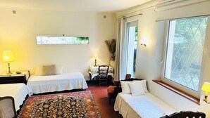 A hotel room with two single beds, a large window, a small table with a lamp, and a decorative rug. - House of 100 m2 on 2 levels with garden of 1000 m2 center Cannes (Cannes)