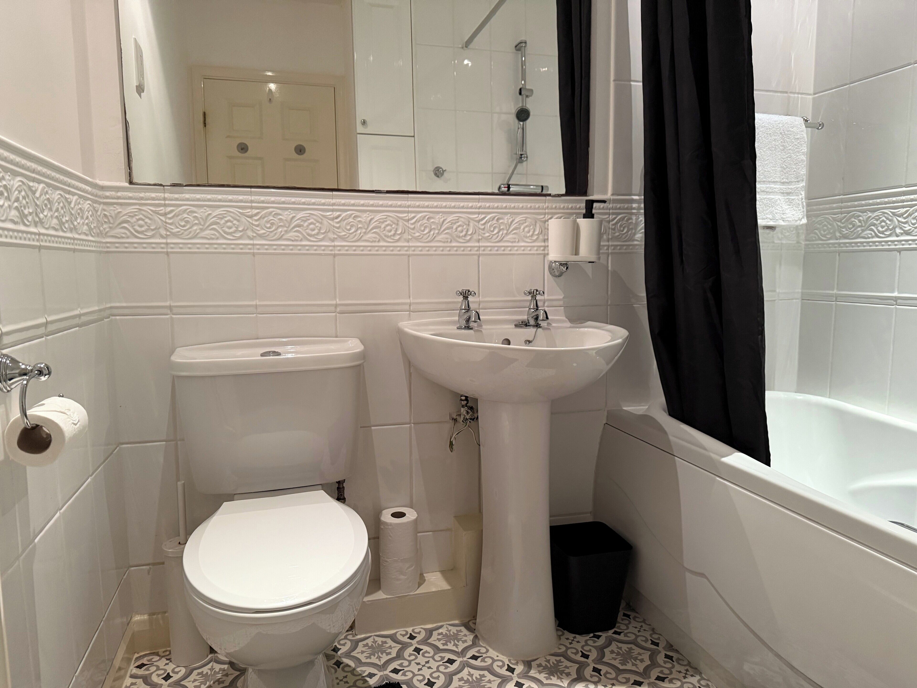 A bathroom with a toilet, sink, and bathtub.