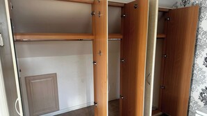 A walk-in closet with wooden doors and a mirrored closet door.