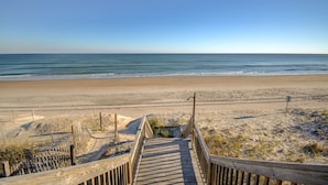 A wooden boardwalk leading to a sandy beach with a clear view of the ocean. - Experience Surf City in style at As You Wish! (Surf City)