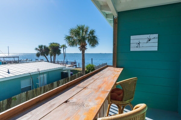 Relax on the balcony with waterfront views and palm trees.