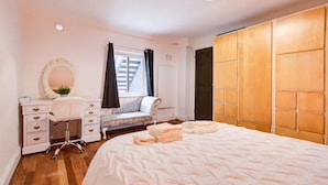 A bedroom with a bed, a desk, a chair, a dresser, a mirror, and a wardrobe. - Stunning London City Apartment Retreat (London)