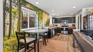 A modern kitchen with dark cabinets, a central island, and a built-in microwave. - Terrace Main | 5BR/3BA  | Spend Spring in Flagstaff! (Flagstaff)