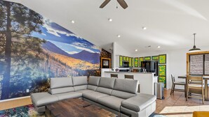 A modern living room with a sectional sofa, a wooden coffee table, and a colorful rug. - Terrace Main | 5BR/3BA  | Spend Spring in Flagstaff! (Flagstaff)