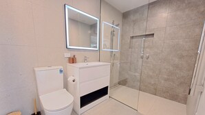 A modern bathroom with a toilet, sink, and shower. - Tainui Charm - Fully renovated, 2 bedrooms (Dunedin)