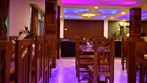 Un restaurante con mobiliario de madera y un diseño de techo moderno.