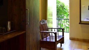 Una habitación con un armario de madera, una cama, una silla y un equipo de aire acondicionado.
