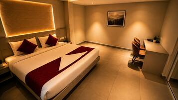 Een moderne hotelkamer met een groot bed, een bureau en een stoel.