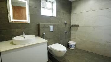 Ein modernes Badezimmer mit Waschbecken, Toilette und Duschbereich.