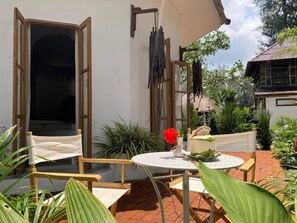 Un patio con una mesa, sillas y una planta en maceta.
