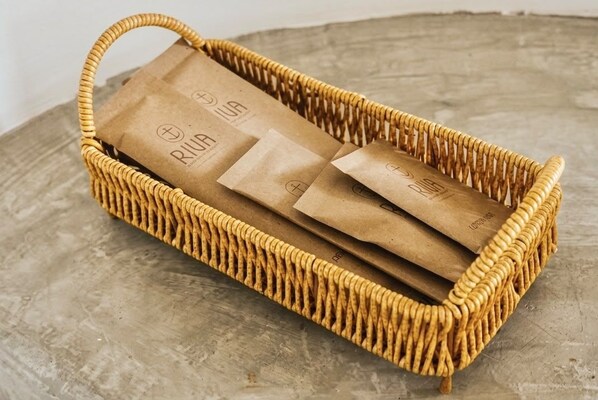 A wicker basket containing brown paper bags with a logo.