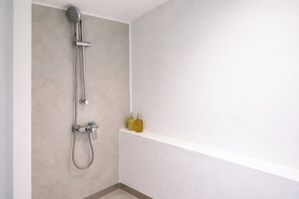 A shower with a handheld showerhead and a wall-mounted faucet. - Riva Boutique Resort Koh Chang (Ko Chang)