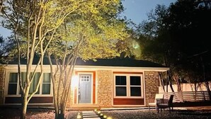 Een huis met een gevel van natuursteen, een voordeur en een pad naar de ingang.