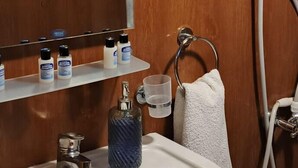 A bathroom with a wooden vanity, a sink, a mirror, and a towel rack. - Jippe İda Dağ Evleri (Edremit)
