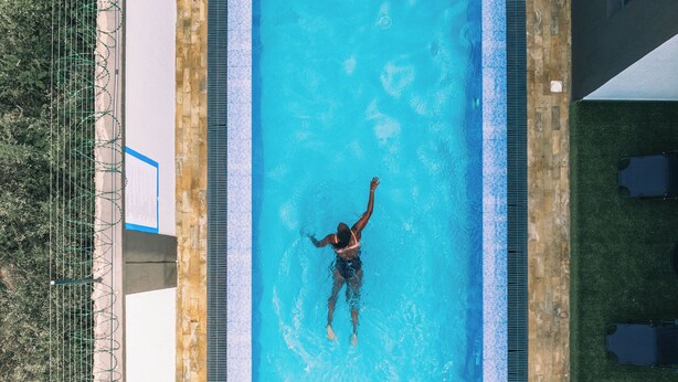 Ein rechteckiger Swimmingpool mit einer darin schwimmenden Person.