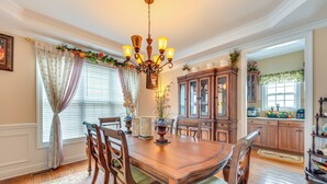 A dining room with a wooden table, chairs, a chandelier, and a cabinet. - 3 Mi to Carowinds: Retreat w/ On-site Fishing (Fort Mill)
