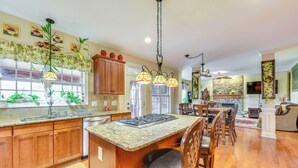 A kitchen with wooden cabinets, a granite countertop, and a central island with seating. - 3 Mi to Carowinds: Retreat w/ On-site Fishing (Fort Mill)