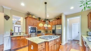 A spacious kitchen with wooden cabinets, a central island, and a stainless steel refrigerator. - 3 Mi to Carowinds: Retreat w/ On-site Fishing (Fort Mill)