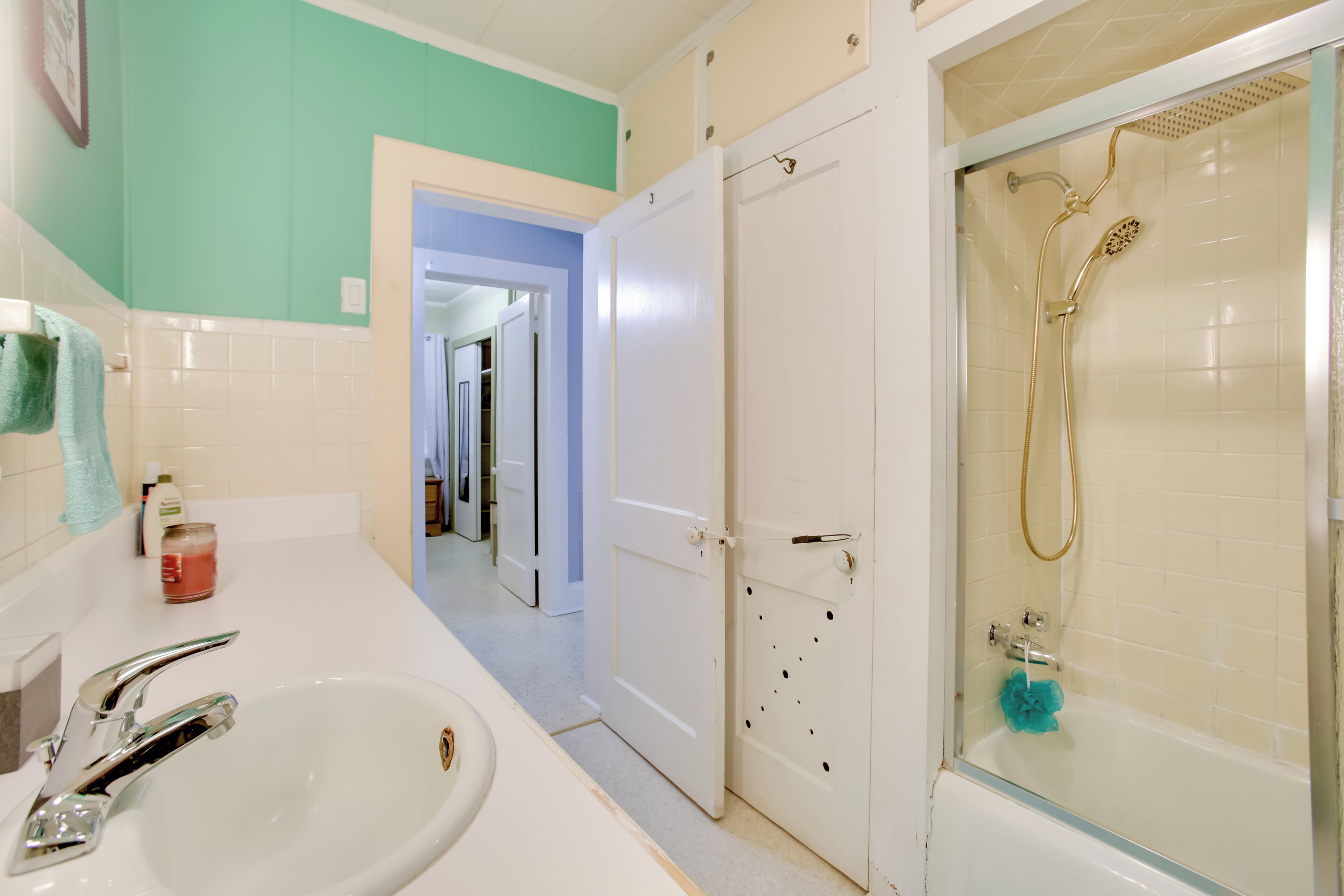 Un baño con lavamanos, espejo y ducha.