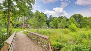 A wooden bridge leading to a playground with green grass and trees. - < 3 Mi to Dtwn: Modern Cottage in Greenville! (Greenville)