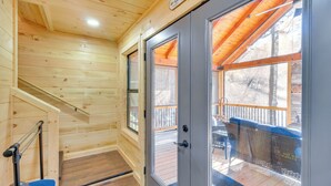 Un interior de madera con un vidrio que da a una terraza exterior.