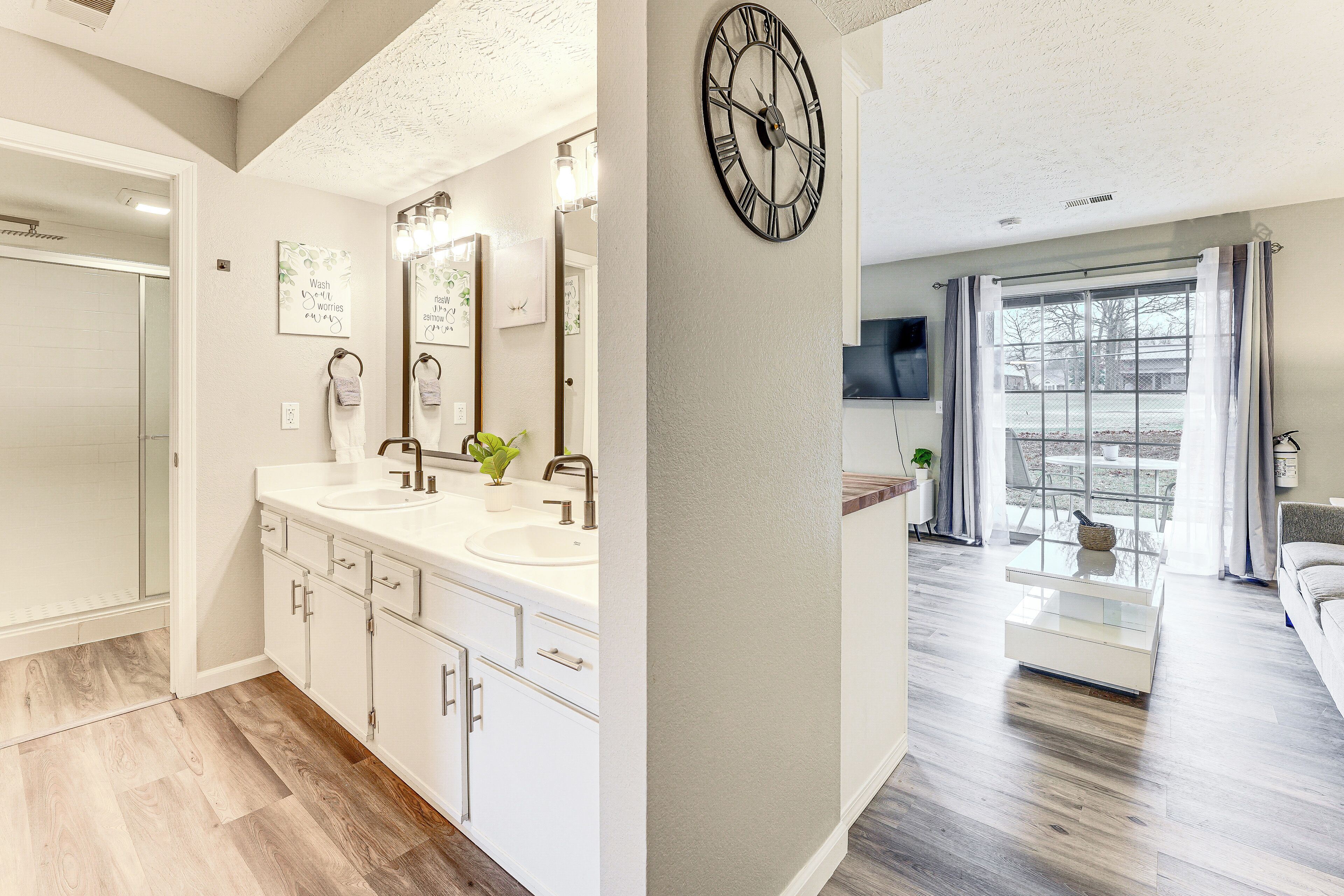 A modern bathroom with a double sink, vanity, and a large mirror.
