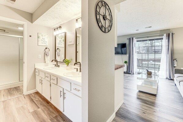 A modern bathroom with a double sink, vanity, and a large mirror.