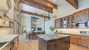 A spacious kitchen with wooden cabinets, a large island, and modern appliances. - Stunning View! Peaceful & Modern Schweitzer Chalet (Sandpoint)