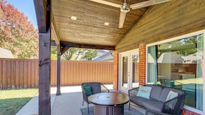 An outdoor patio with wicker furniture, a round table, and a ceiling fan. - Outdoor Oasis w/ Pool: Grand Prairie Family Home! (Grand Prairie)