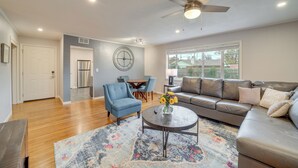 A spacious living room with a sofa, armchair, coffee table, and a dining area with chairs and a table. - 6 Mi to Dtwn: Dog-friendly Home w/ Yard in Tulsa (Tulsa)