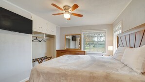 A bedroom with a bed, a ceiling fan, a dresser, a mirror, and a window. - 6 Mi to Dtwn: Dog-friendly Home w/ Yard in Tulsa (Tulsa)