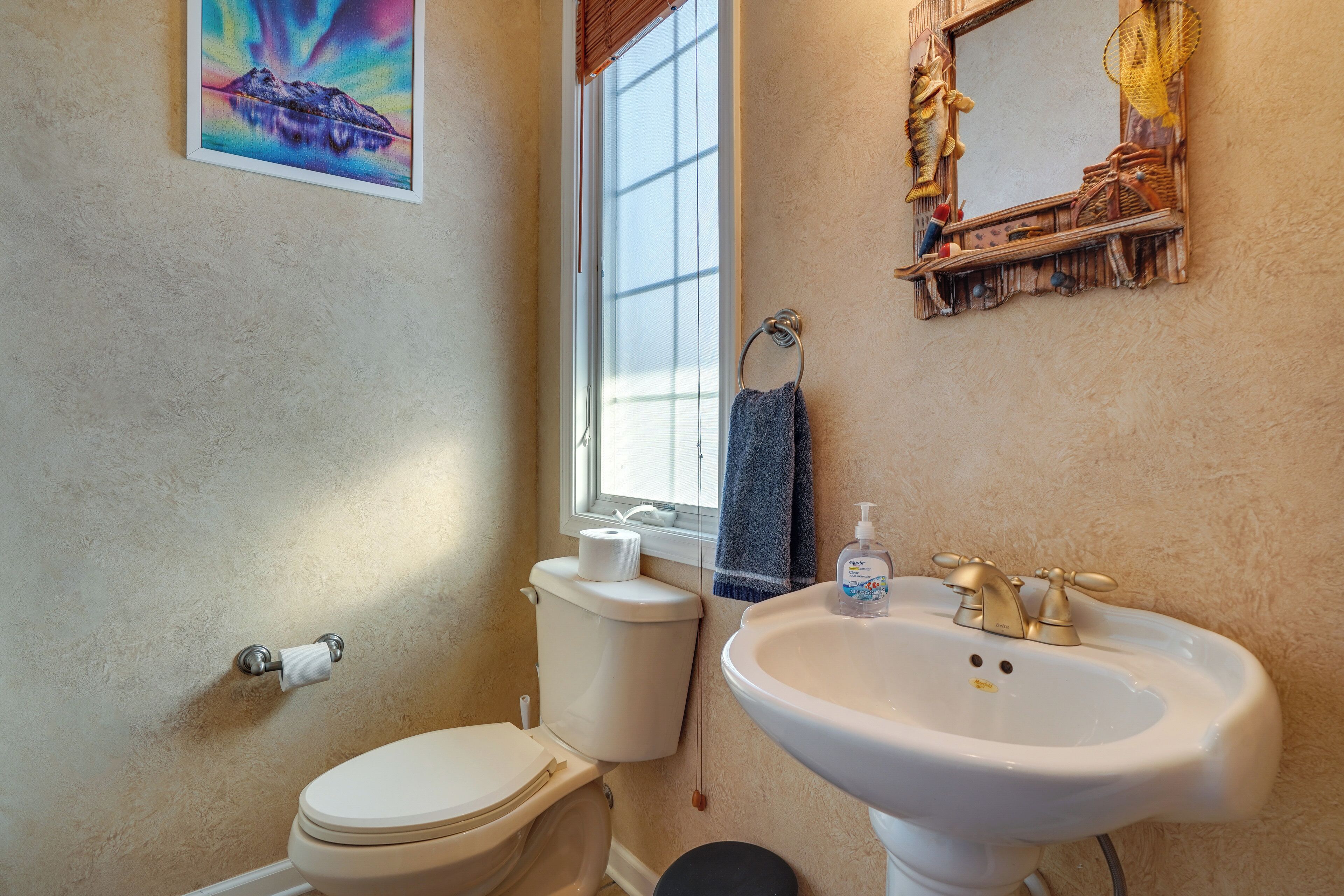 Ein Badezimmer mit Toilette, Waschbecken und einem Fenster.