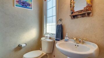 Ein Badezimmer mit Toilette, Waschbecken und einem Fenster.