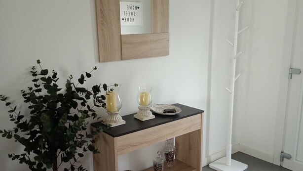 A room with a wooden console table, a potted plant, a mirror with a 'HOME SWEET HOME' sign, a coat rack, and a tiled floor. - House pontevedra, enjoys tranquility 5 min from the beach and 3 min from downtown  (Pontevedra)