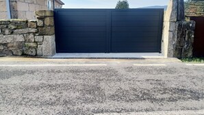A closed black garage door with stone walls on either side. - House pontevedra, enjoys tranquility 5 min from the beach and 3 min from downtown  (Pontevedra)