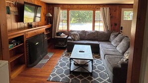 Una sala de estar acogedora con chimenea, televisor, sofá y mesa de centro.