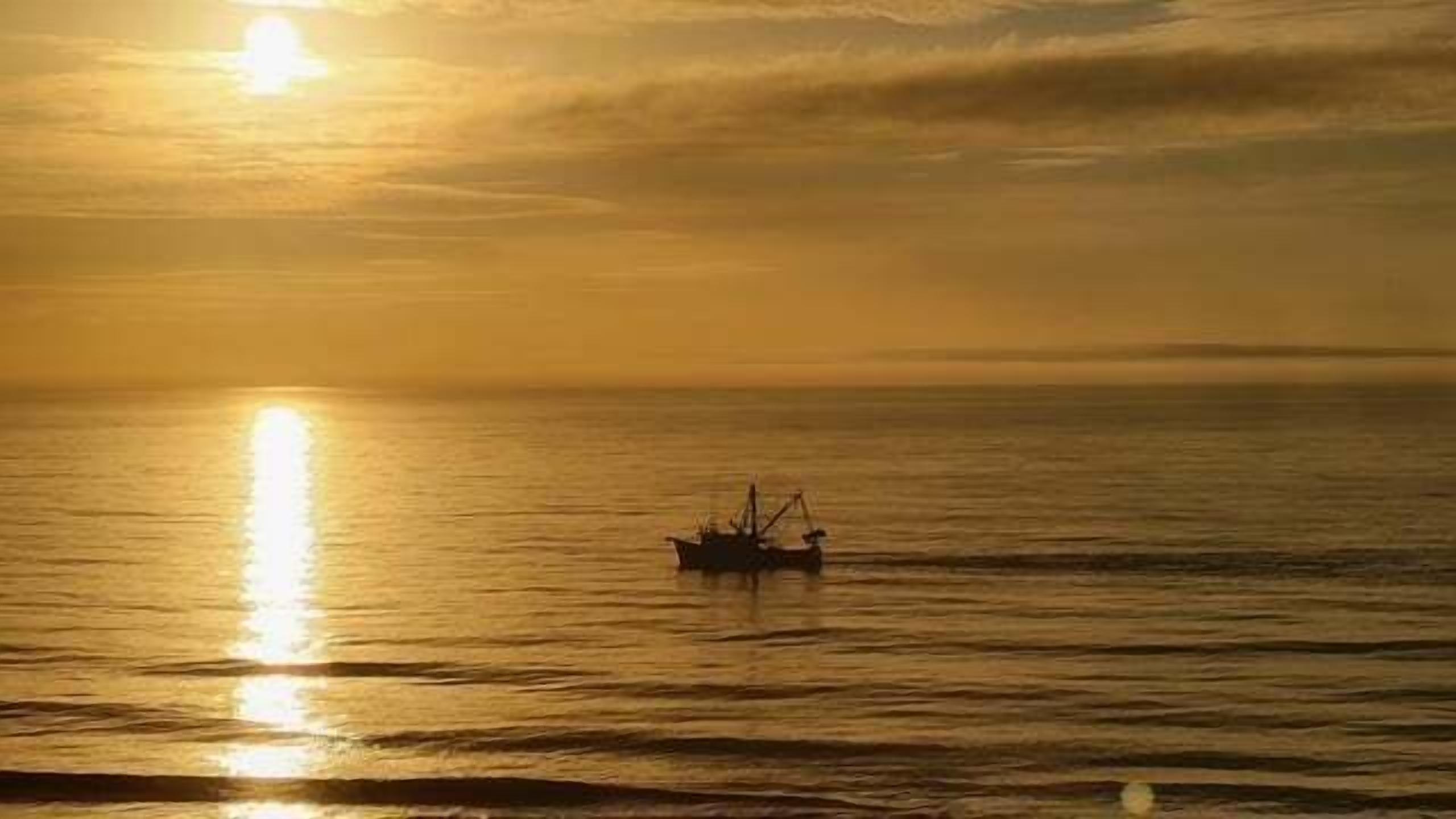 A boat on calm waters during sunset.