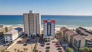 Un hôtel de grande hauteur doté d’une cour intérieure, d’un parking et offrant une vue sur la plage.