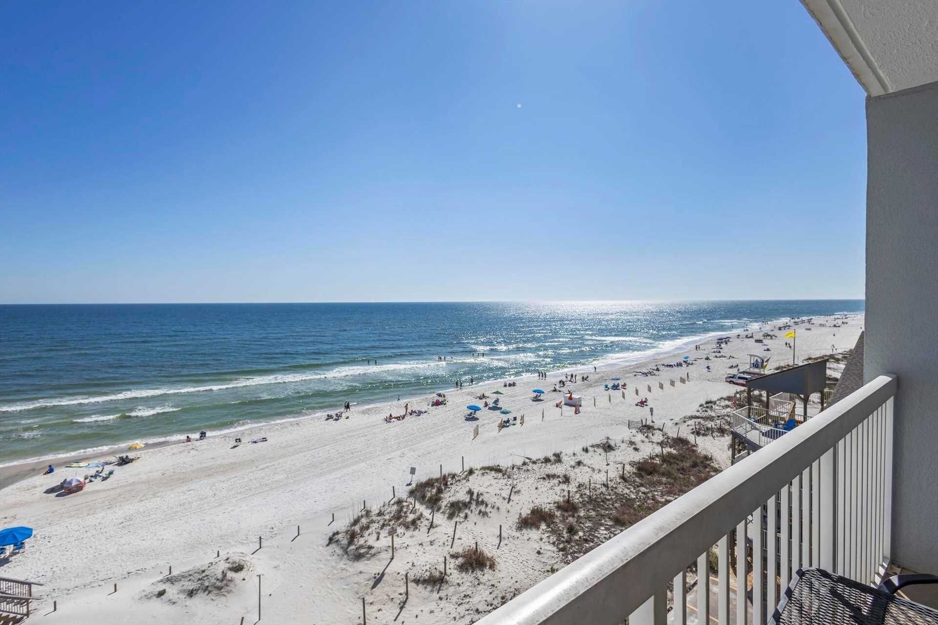 A beach with a clear view of the ocean and a balcony overlooking the beach.