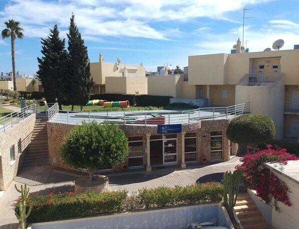 Un immeuble à la façade en pierre, avec un escalier menant à un toit plat et une enseigne indiquant qu’il s’agit d’un immeuble en copropriété.