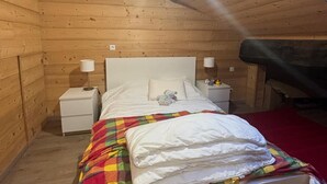 A cozy wooden cabin bedroom with a bed, nightstands, and a skylight. - Village house Val cenis (Val-Cenis)