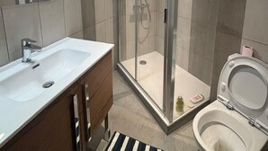 A modern bathroom with a glass-enclosed shower, a white sink, and a toilet. - Village house Val cenis (Val-Cenis)