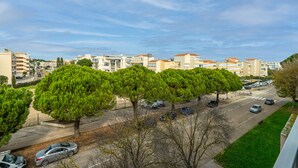 A residential area with apartment buildings, a road, and parked cars.