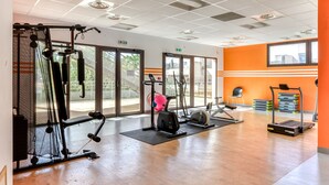 A gym with cardio machines, weightlifting equipment, and a large window providing natural light. - Bright, air-conditioned appartement 4 ppl,  close to the sea (Le Grau-du-Roi)