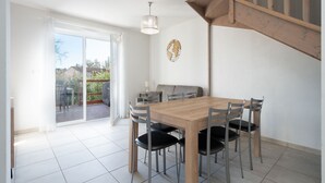 A dining area with a wooden table and chairs, a globe decoration, and a staircase. - Villa with garden near the beach for 6 pers (Sérignan)